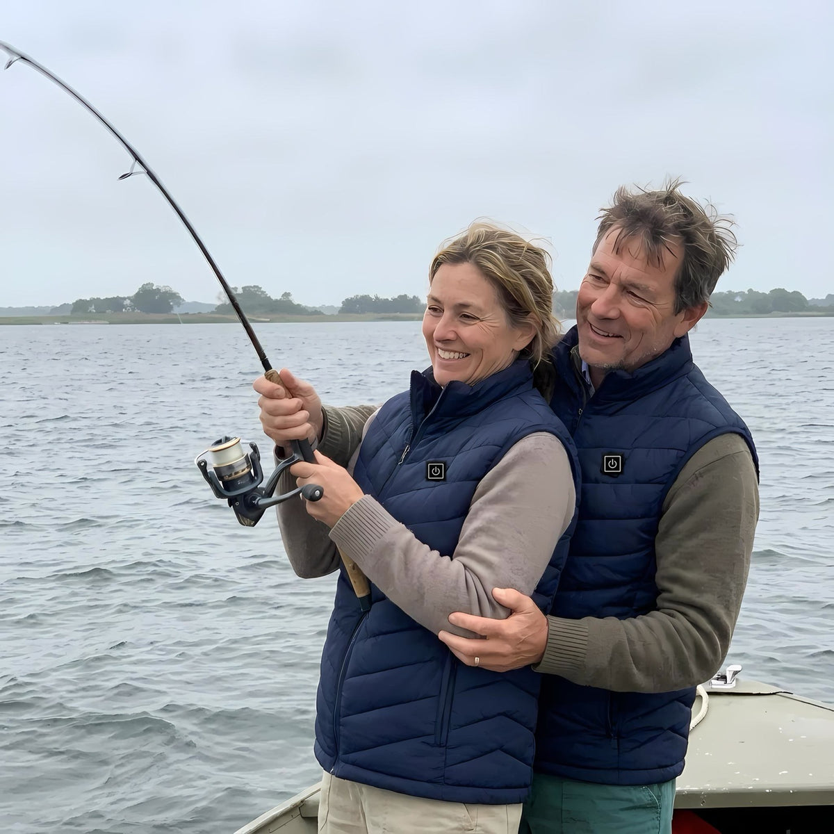 Couple ice fishing on the shore wearing OXYZ Heated Vests