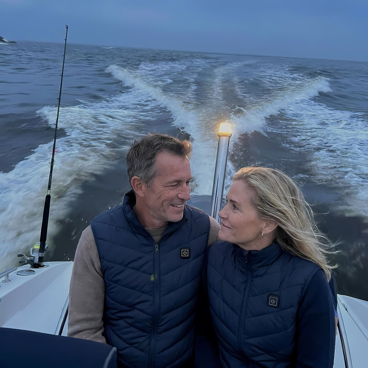 Couple wearing OXYZ Heated Vests on a boat in cold weather